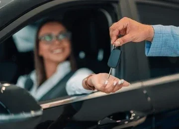 Person in car receiving car keys from another person