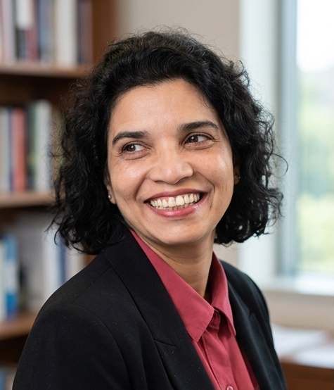 women with black short hair with a black blazer and red button up shirt, smiling