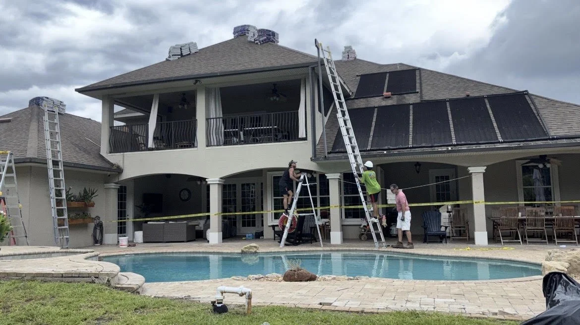 Construction crew working on a residential property with ladders and roof equipment