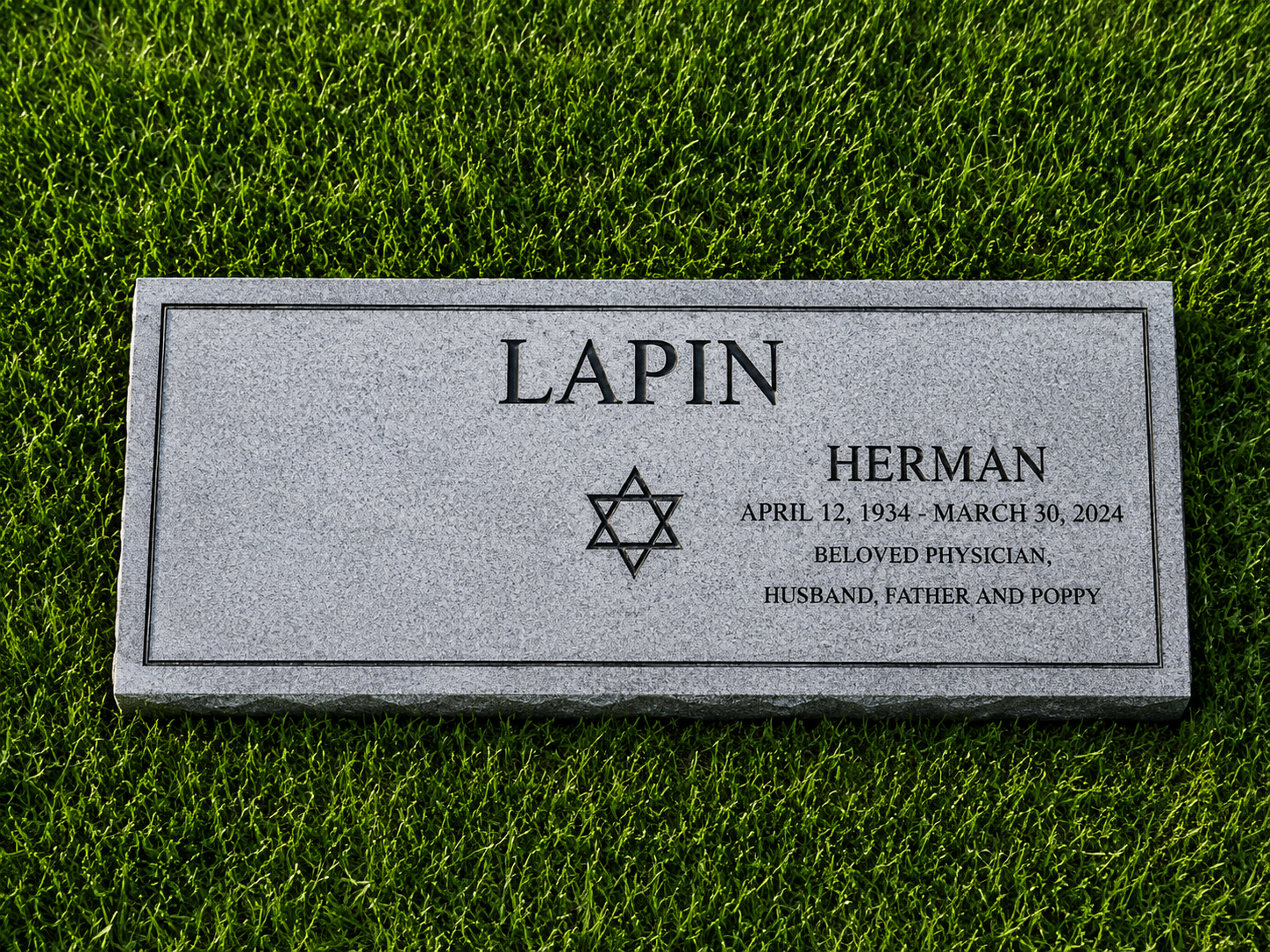 Gravestone for Herman Lapin with Star of David, July 12, 1934 - March 30, 2024, indicating he was a beloved physician, husband, father, and Poppy, on a grassy area.