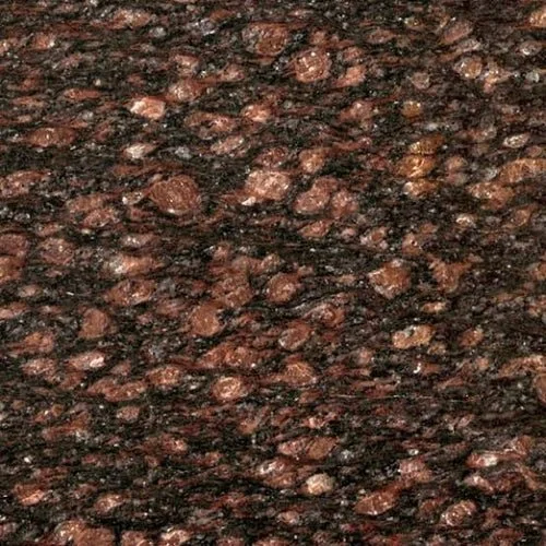 Close-up of a textured granite surface with dark and reddish-brown speckles.