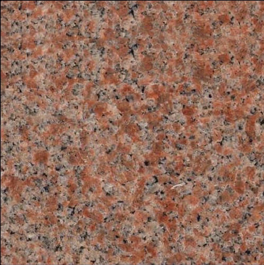 Close-up of a speckled granite surface with orange, black, and gray colors.