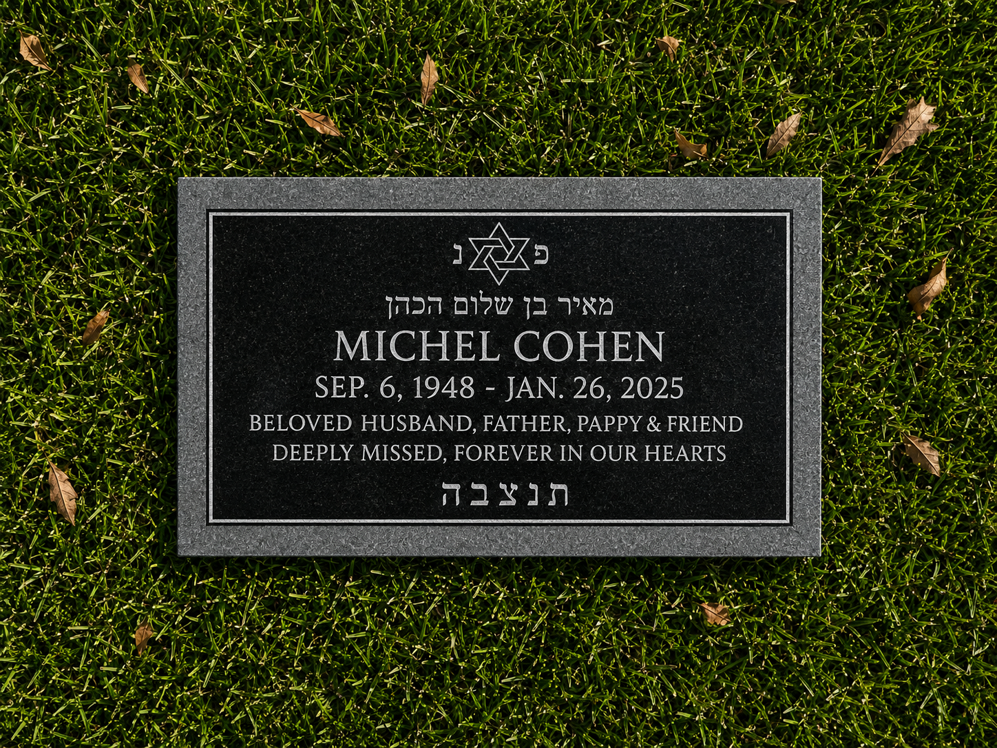 Gravestone for Michel Cohen, surrounded by grass with some fallen leaves, bearing Hebrew and English inscriptions honoring his memory.