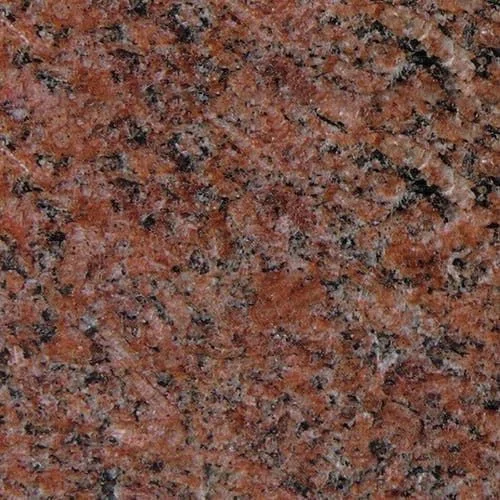 Close-up of a polished, reddish-brown granite countertop with black and white mineral speckles.