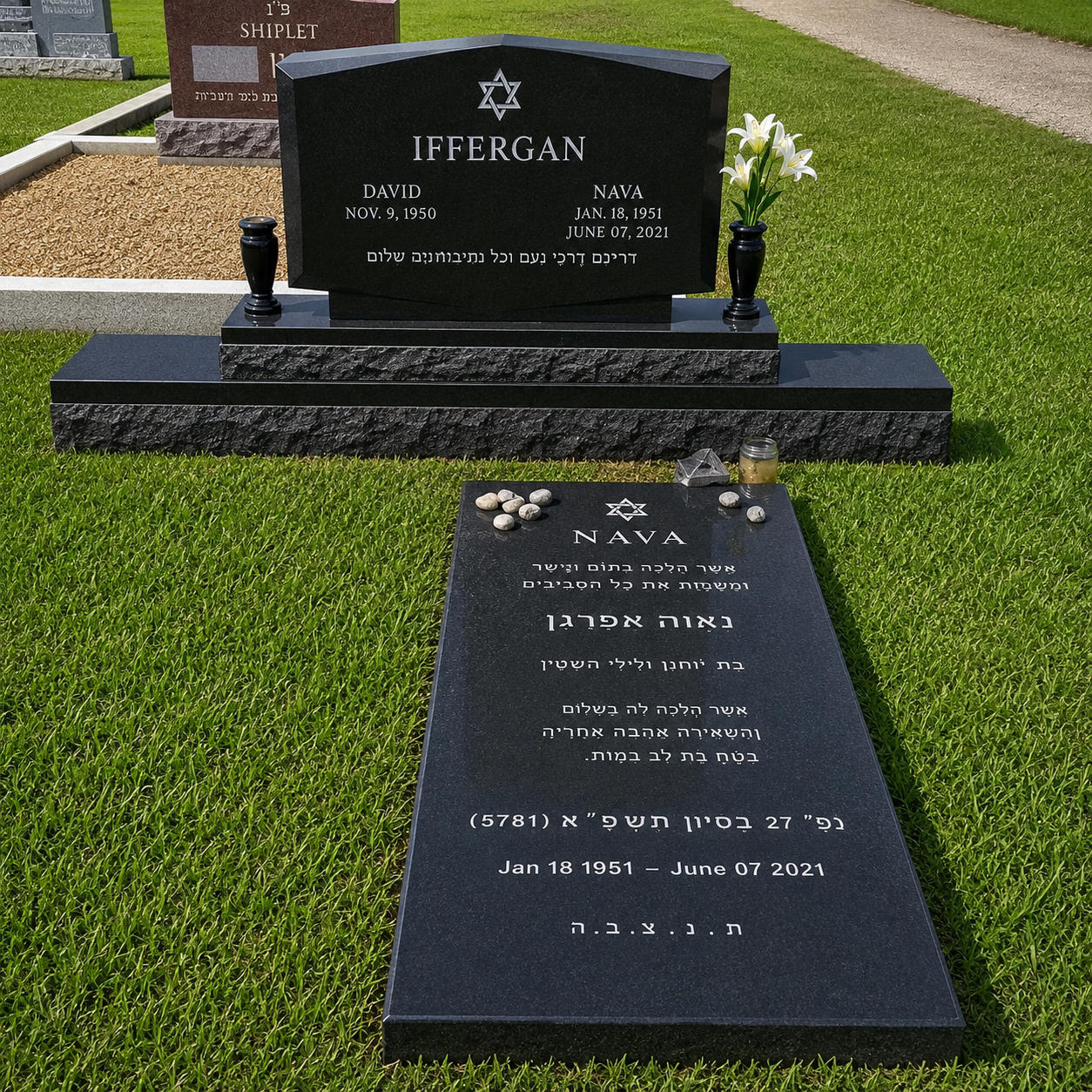 A black granite grave monument with Hebrew and English inscriptions for David and Nava Ifferan, featuring a Star of David symbol, with a vase of white lilies on the right side. In front, a flat black tombstone with a Star of David, rocks, a candle holder, and a small decorative item, marking their burial site.
