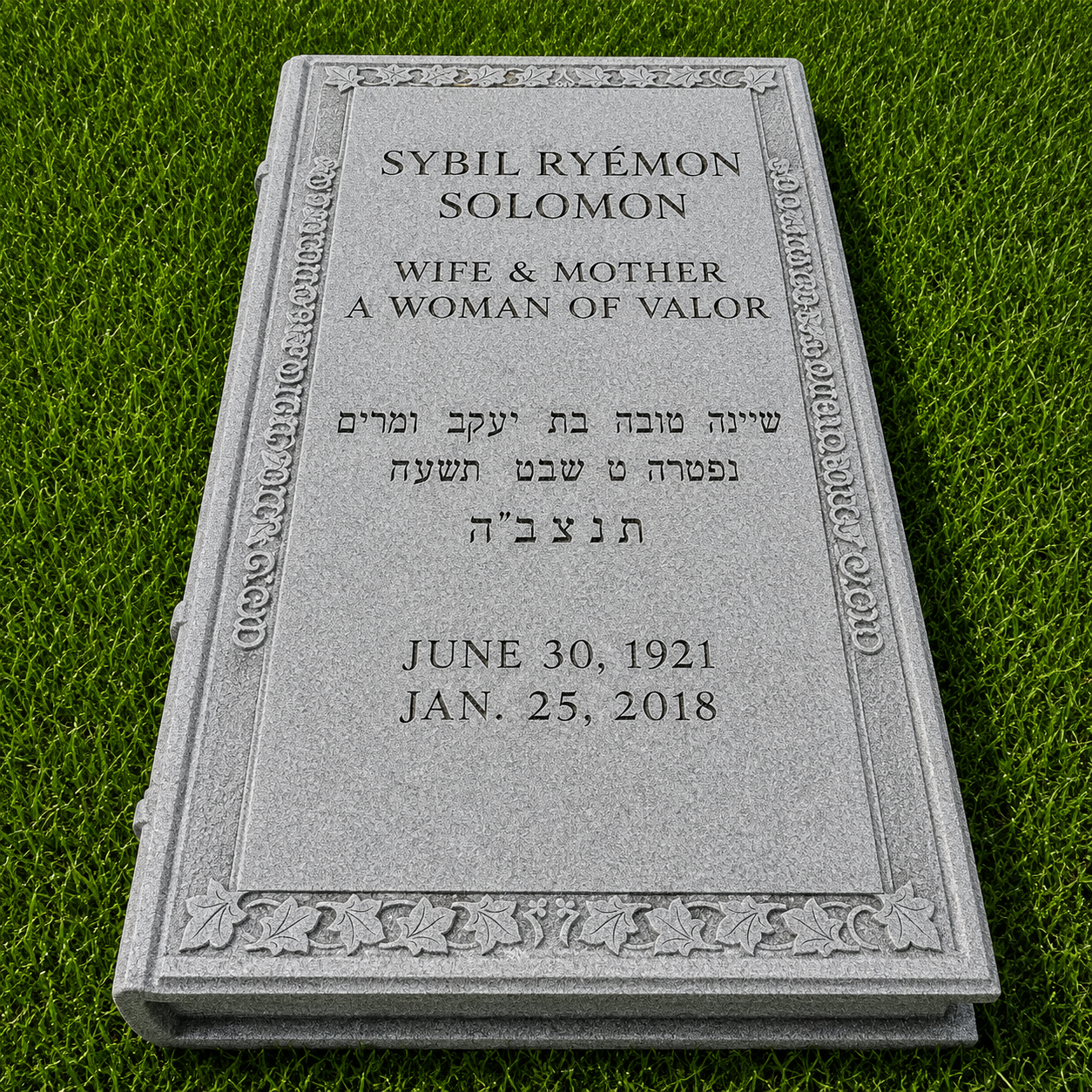Gravestone with engraved text honoring Sybil Ryemon Solomon, wife and mother, described as a woman of valor, with inscriptions in English and Hebrew, on a grassy background.