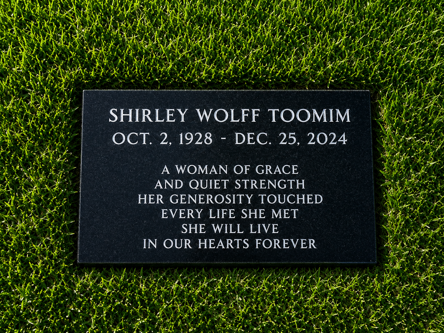 Gravestone in a grassy area for Shirley Wolff Toomim, with birth and death dates, and an inscription about her grace, strength, generosity, and remembrance.