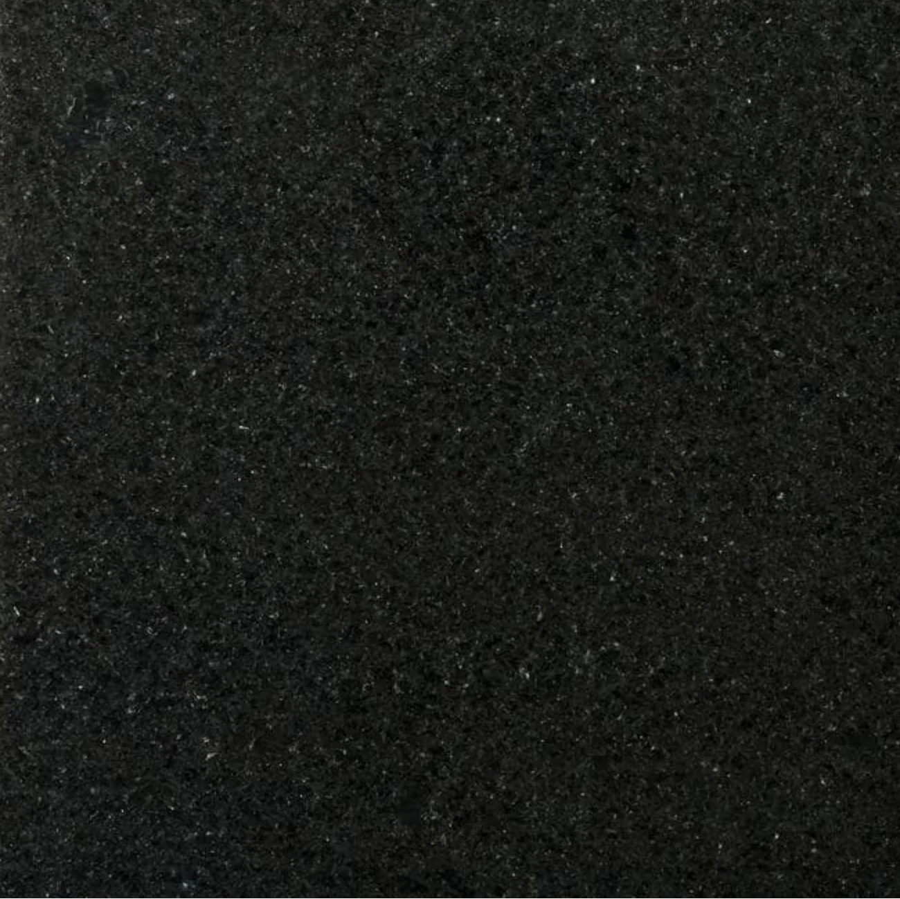 Close-up photograph of black glittery surface with sparkly specks.