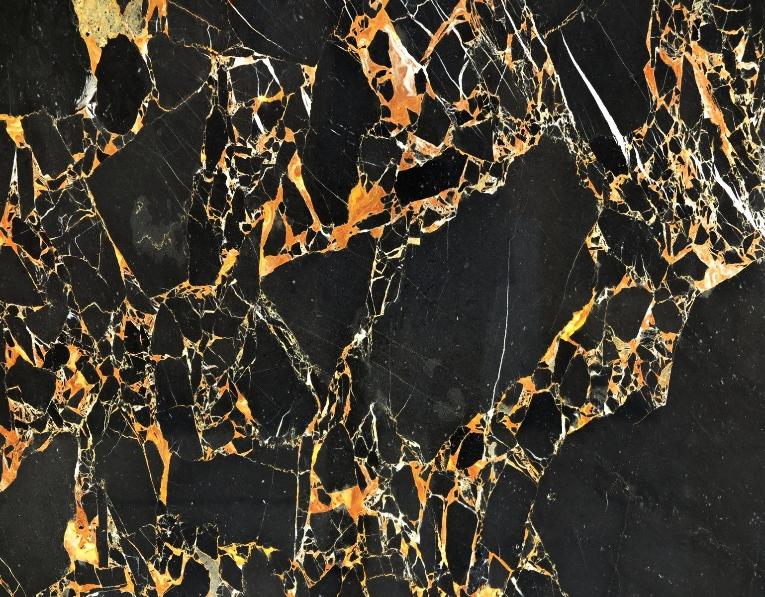 Close-up of black marble surface with orange, white, and gold veining
