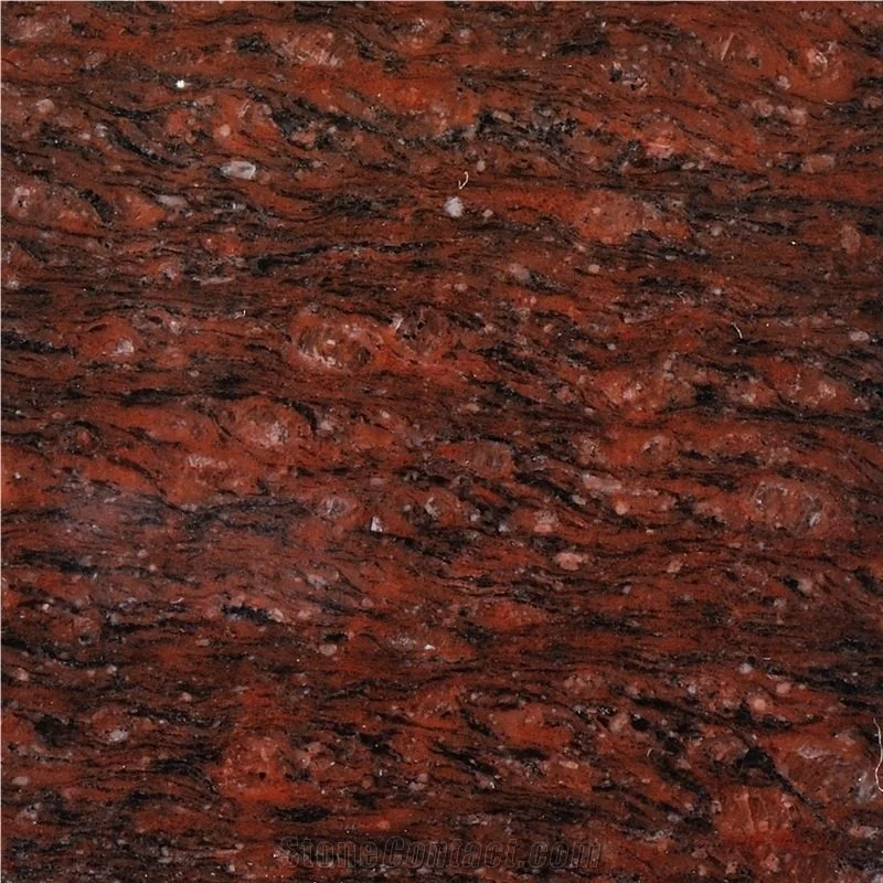 Close-up of polished red granite countertop with black and white speckles.