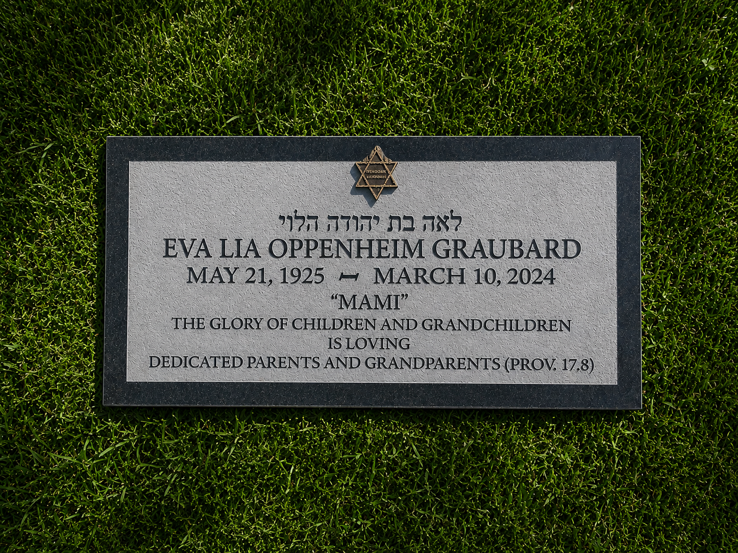 Gravestone with Hebrew and English text, surrounded by grass, honoring Eva Lia Oppenheim Graubard, with dates 1925-2024, dedicated by family members.