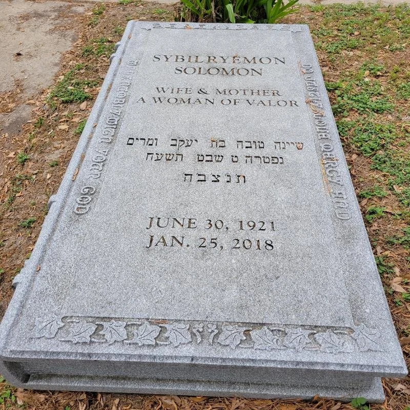 Gravestone inscribed in English, Hebrew, and possibly another language.