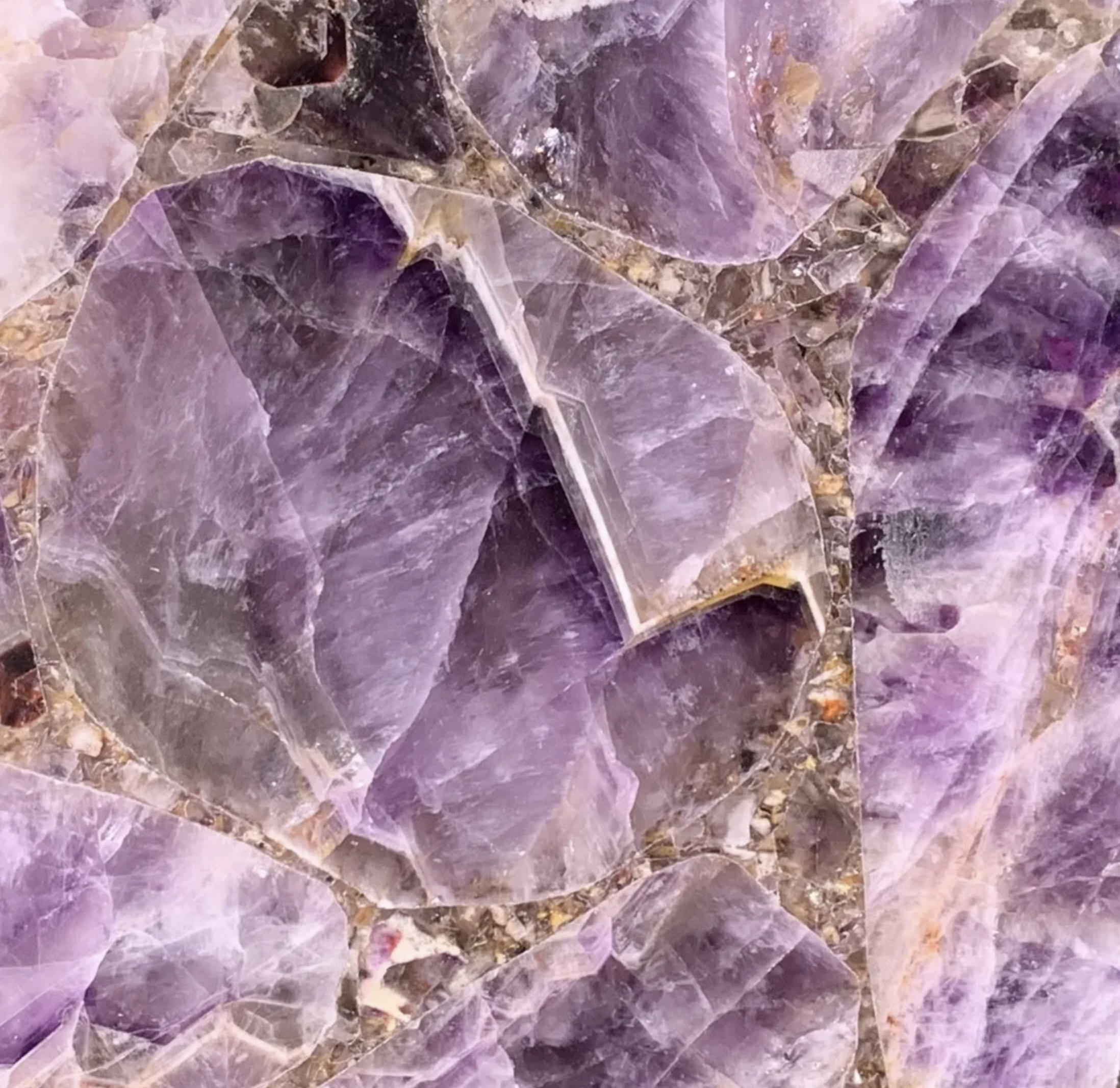 Close-up of natural purple crystals with varying shades and transparent facets.