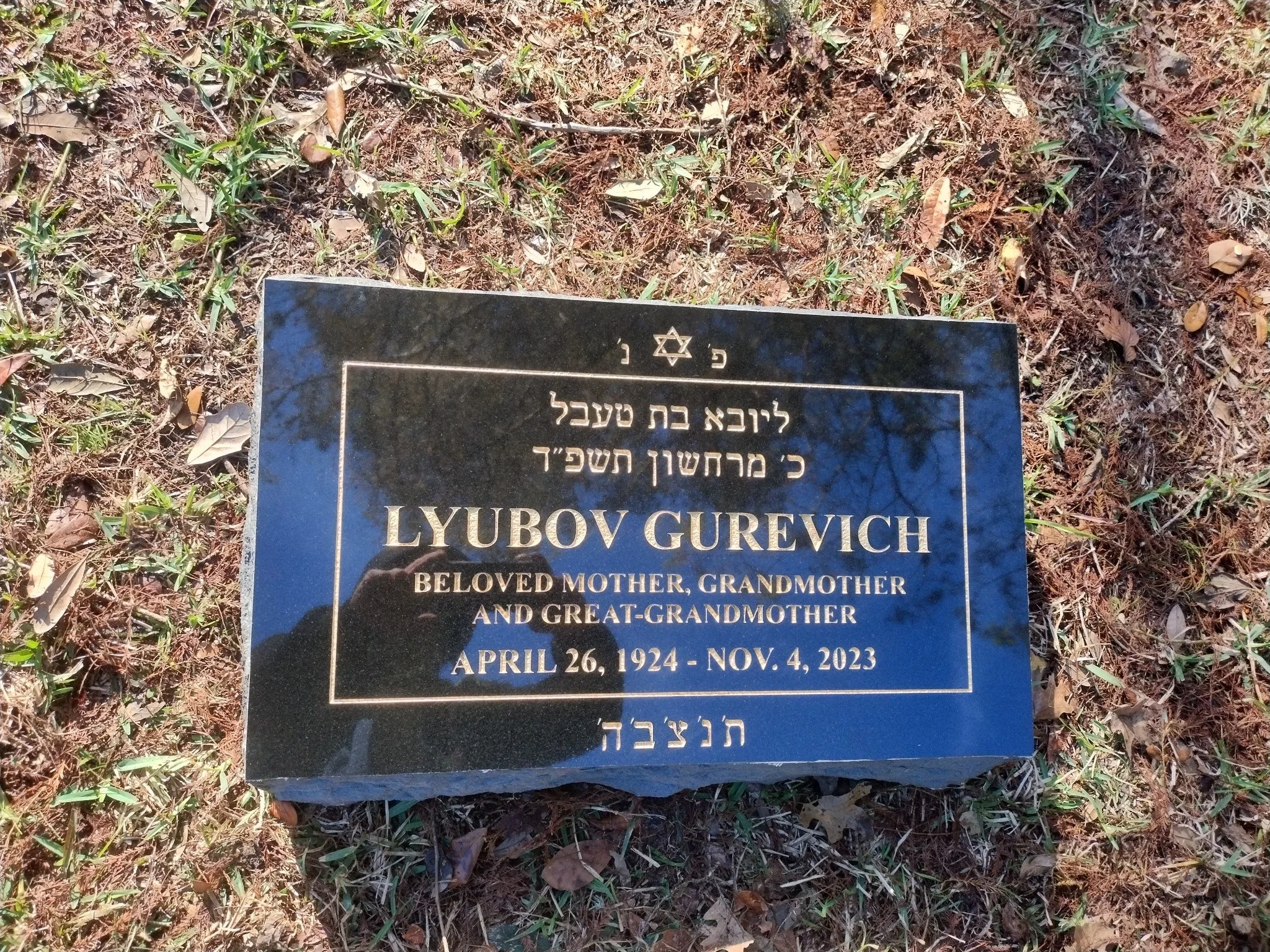Gravestone with engraved text in Hebrew and English.