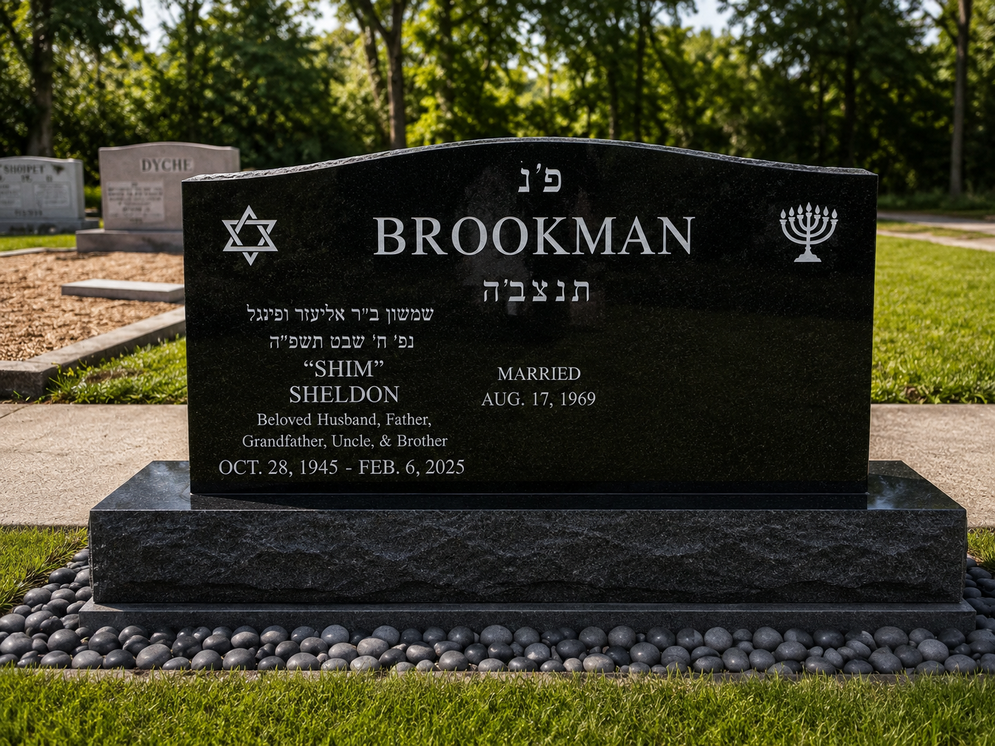Black granite headstone with Hebrew and English inscriptions for Brookman, Shlomo (Sheldon), married August 17, 1969, dates October 28, 1945, to February 6, 2025, with symbols of a Star of David and a menorah, placed on a bed of black stones in a grassy cemetery.