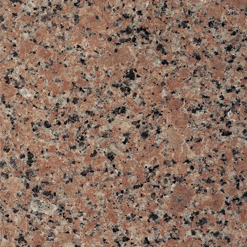 Close-up of a granite countertop with a speckled pattern of pink, black, and gray minerals.
