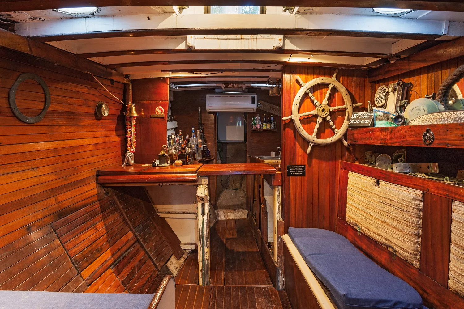 Interior of the shipwreck-themed pool house with a wood bar and nautical details
