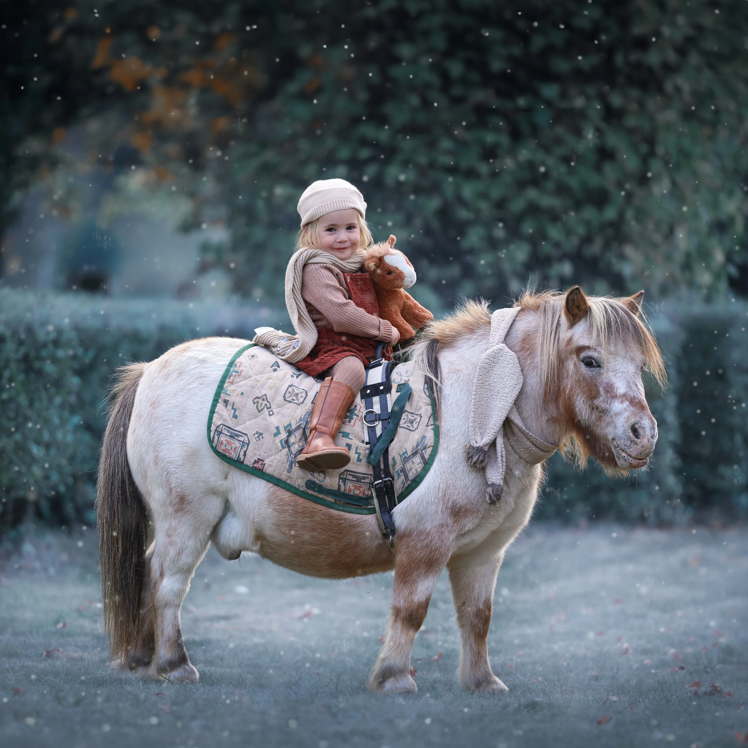 kinderfotografie-kind-met-knuffelpaardje-op-pony-sneeuwfoto.jpg