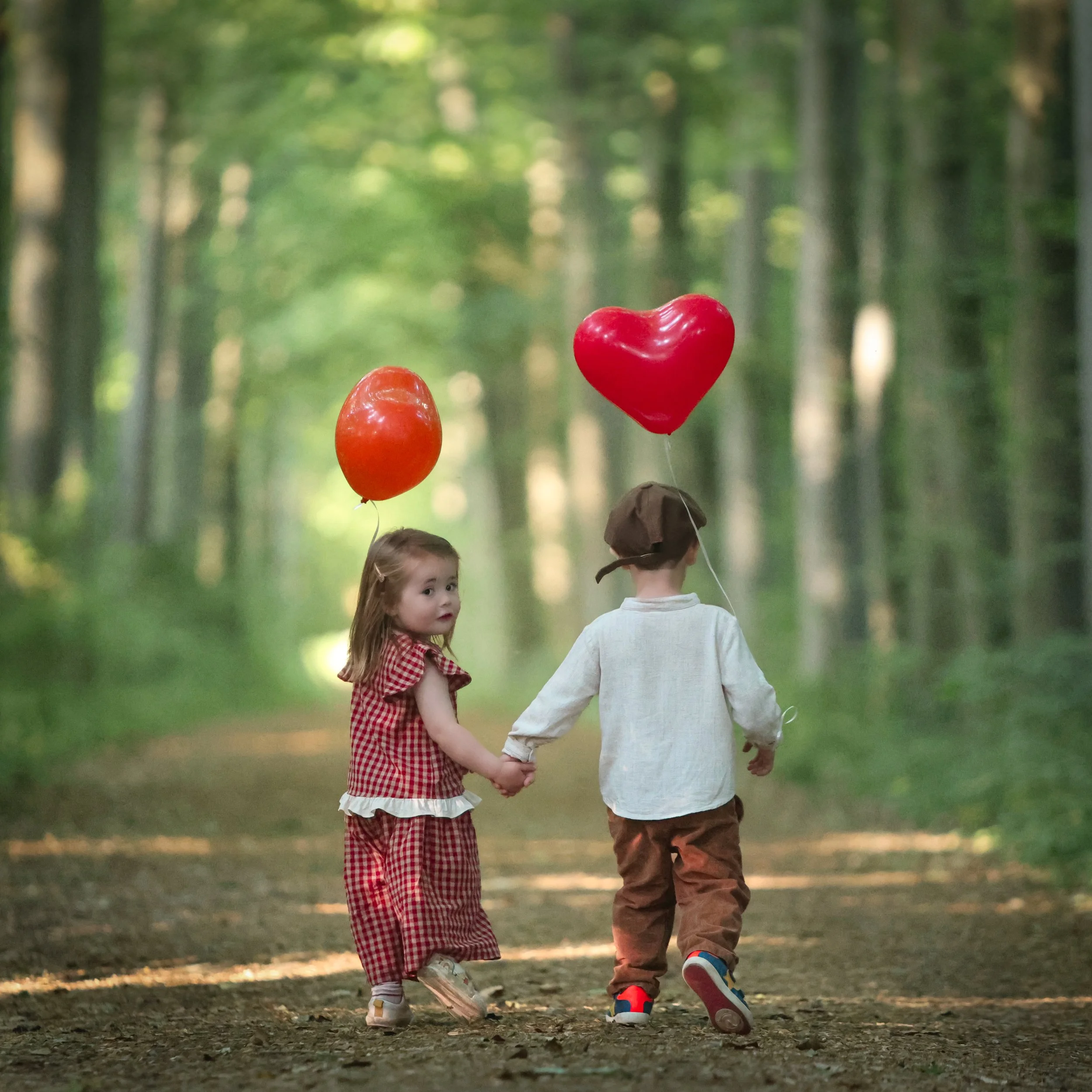 kinderfotografie-hand-in-hand-in-het-bos-met-ballon.jpg