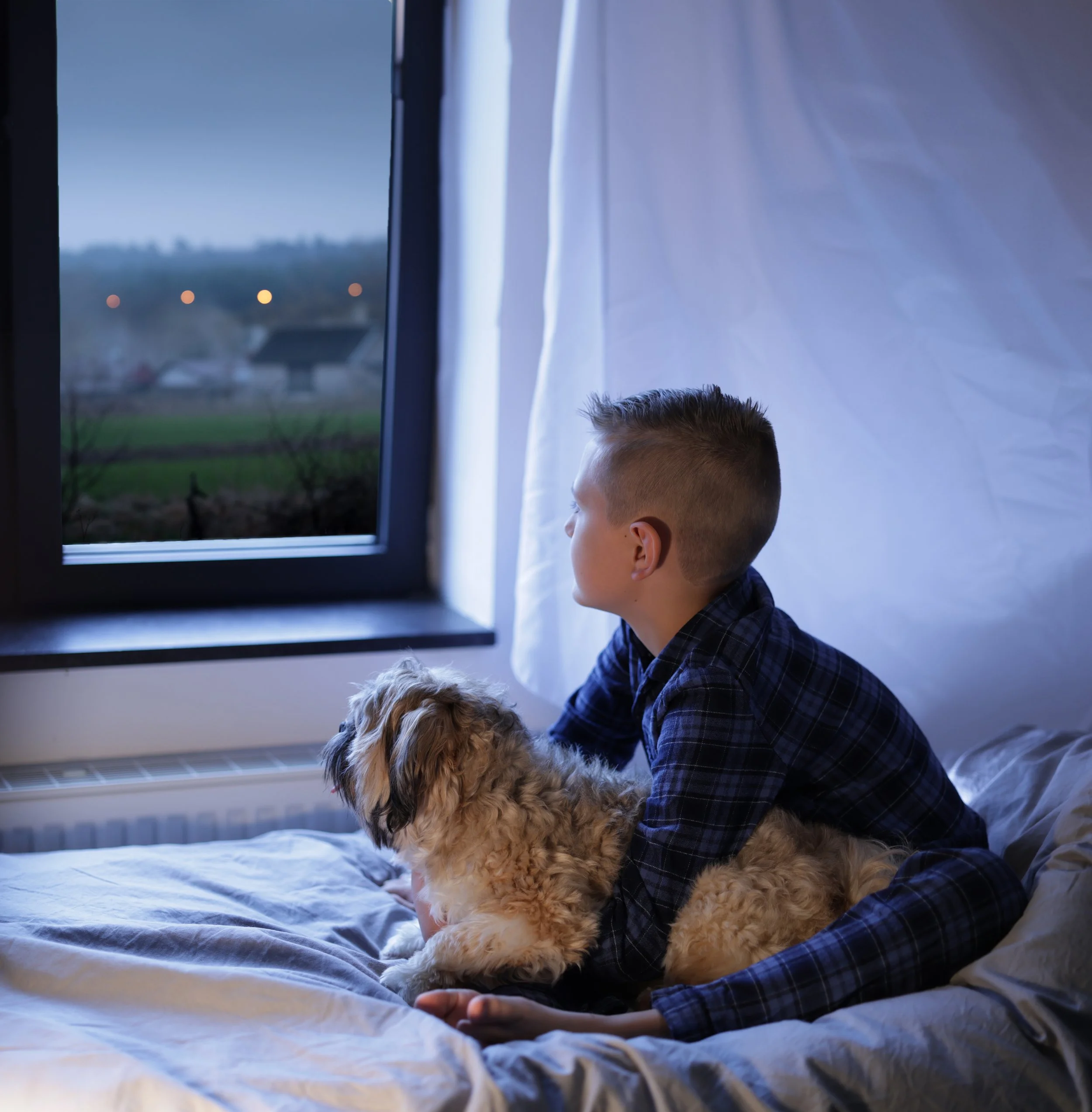 kinderfotografie-kind-kijkt-met-hond-uit-raam.jpg