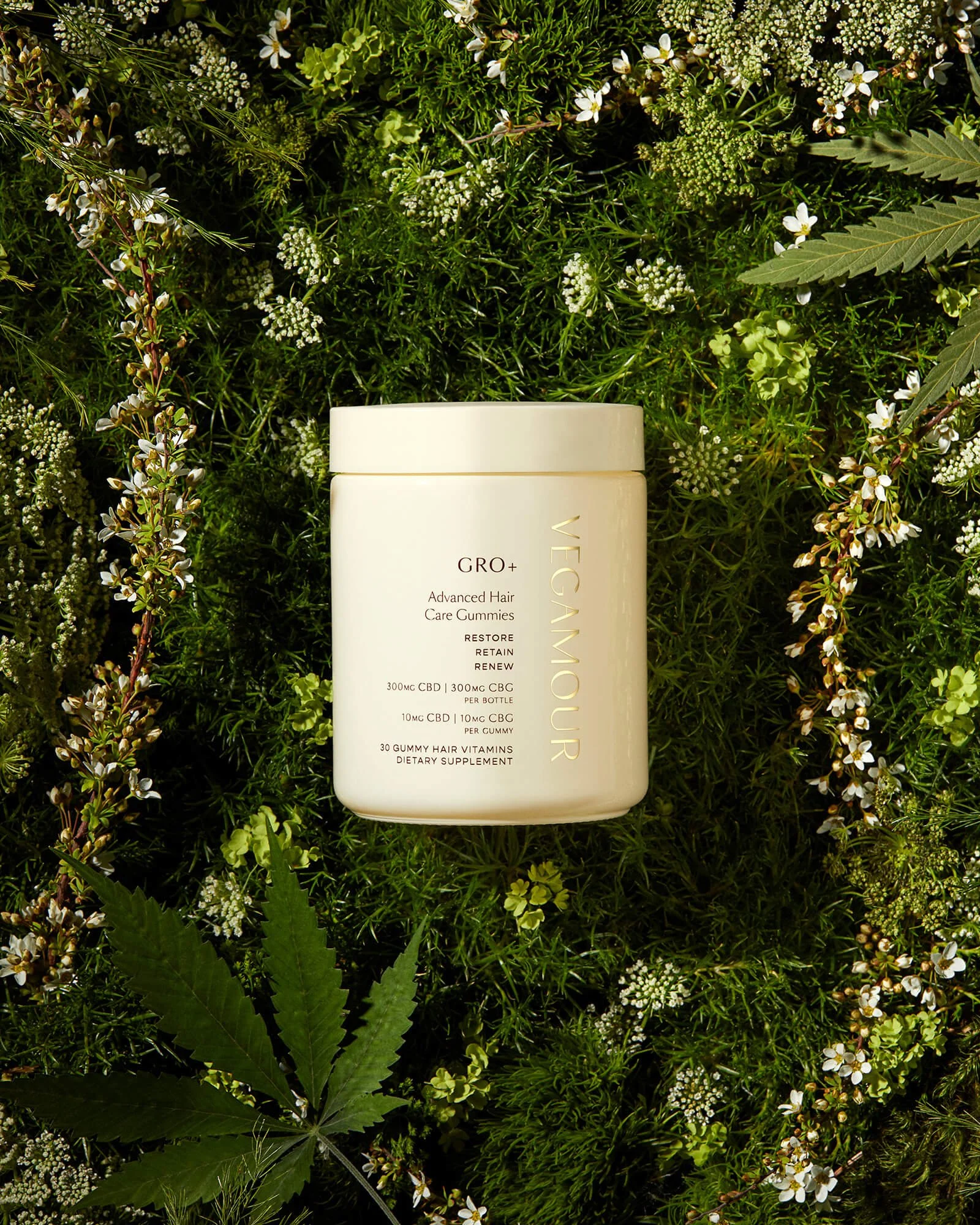 Vegan hair care gummies container on green foliage background, labeled "GRO+ Advanced Hair Care Gummies."
