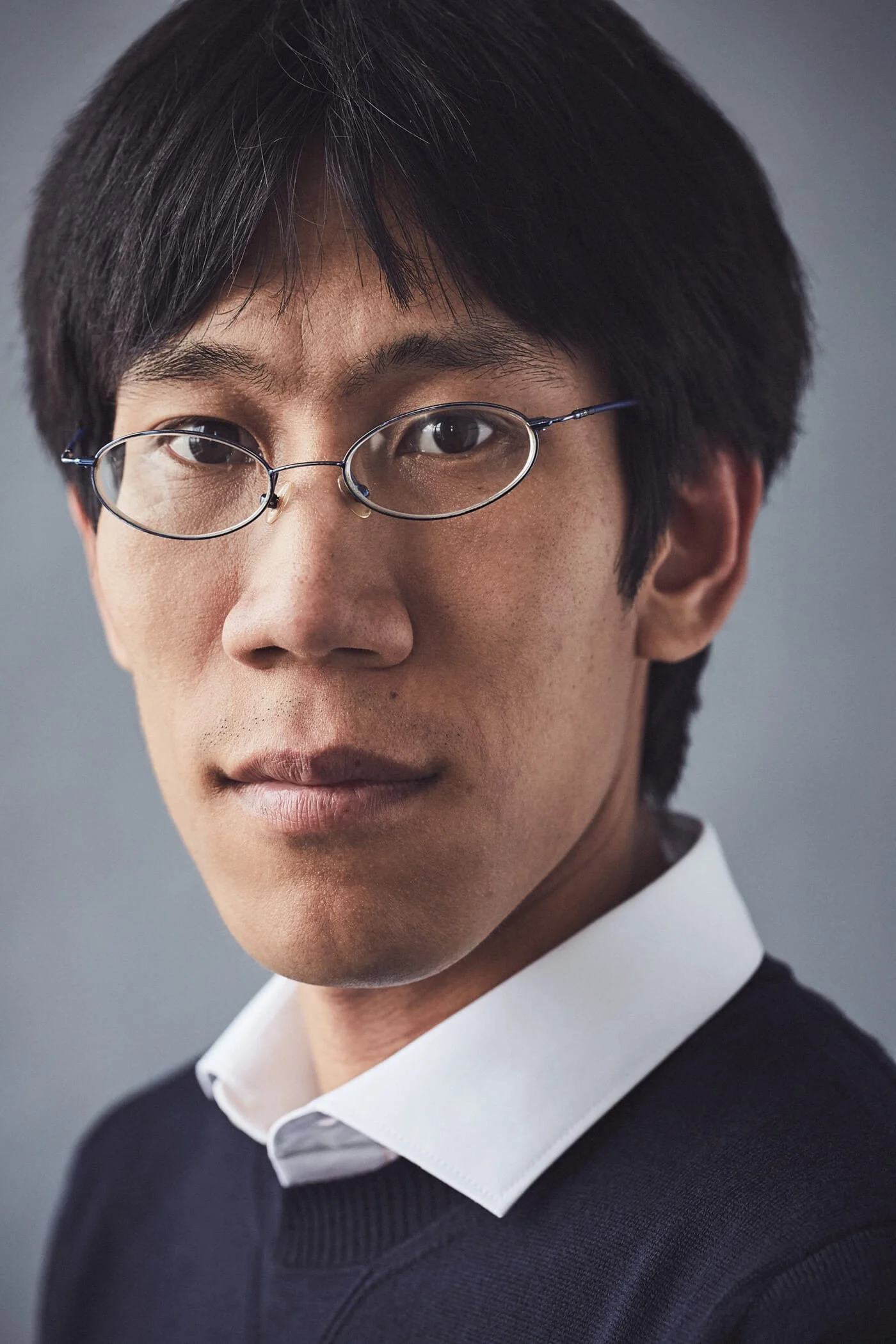 Person wearing glasses and a white collared shirt