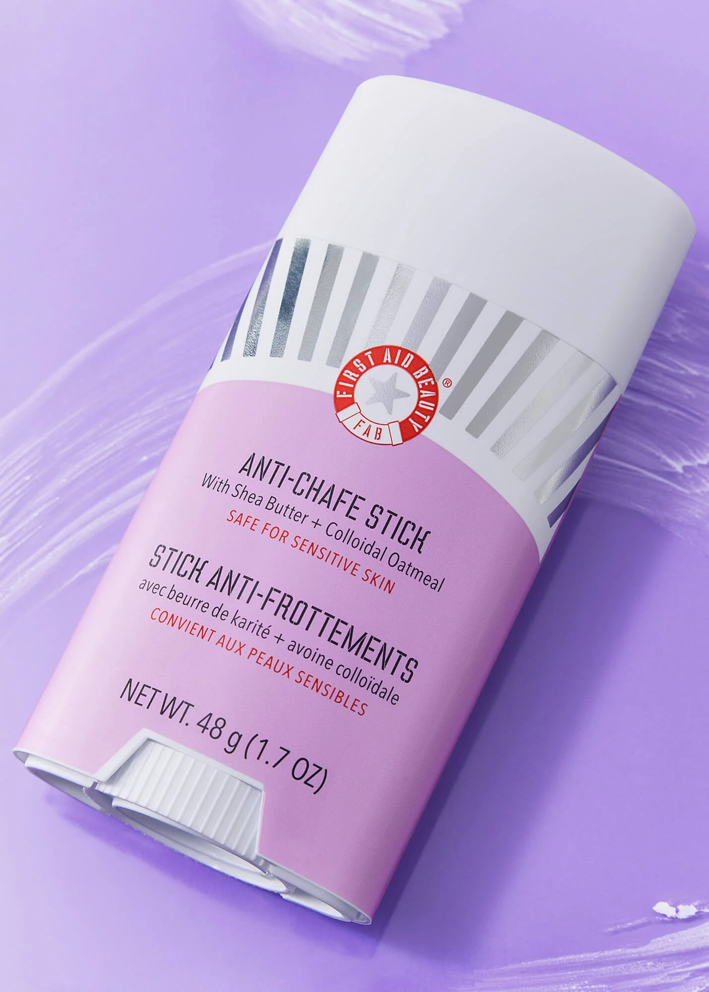 Anti-chafe stick with purple background, labeled "First Aid Beauty" containing shea butter and colloidal oatmeal, designed for sensitive skin. Net weight 48g (1.7 oz).