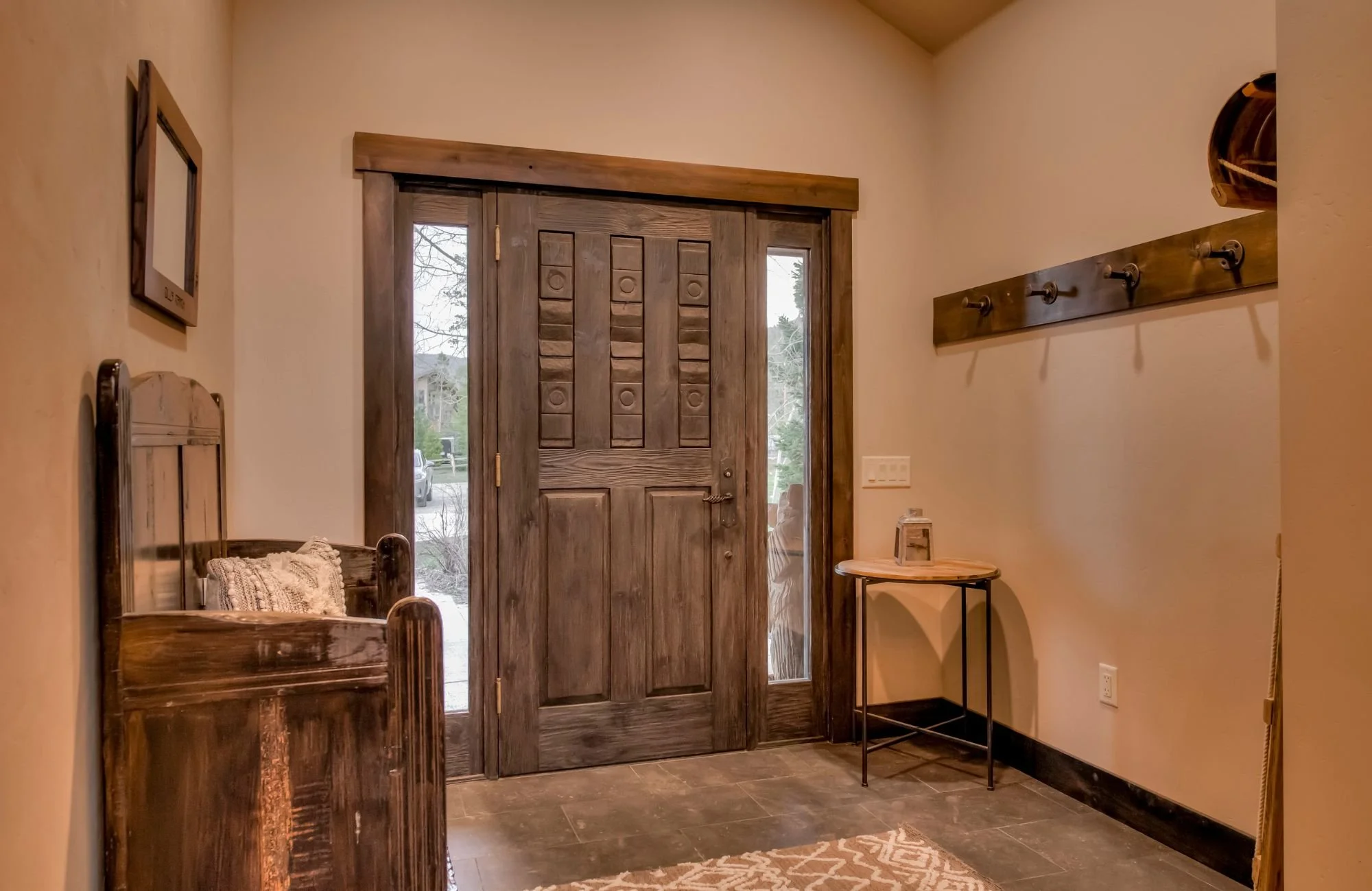 harmony-interiors-breckenridge-co-second-home-in-the-mountains-entryway-with-heavy-wood-door-bench-and-coat-hooks-creative-home-renovation.jpg