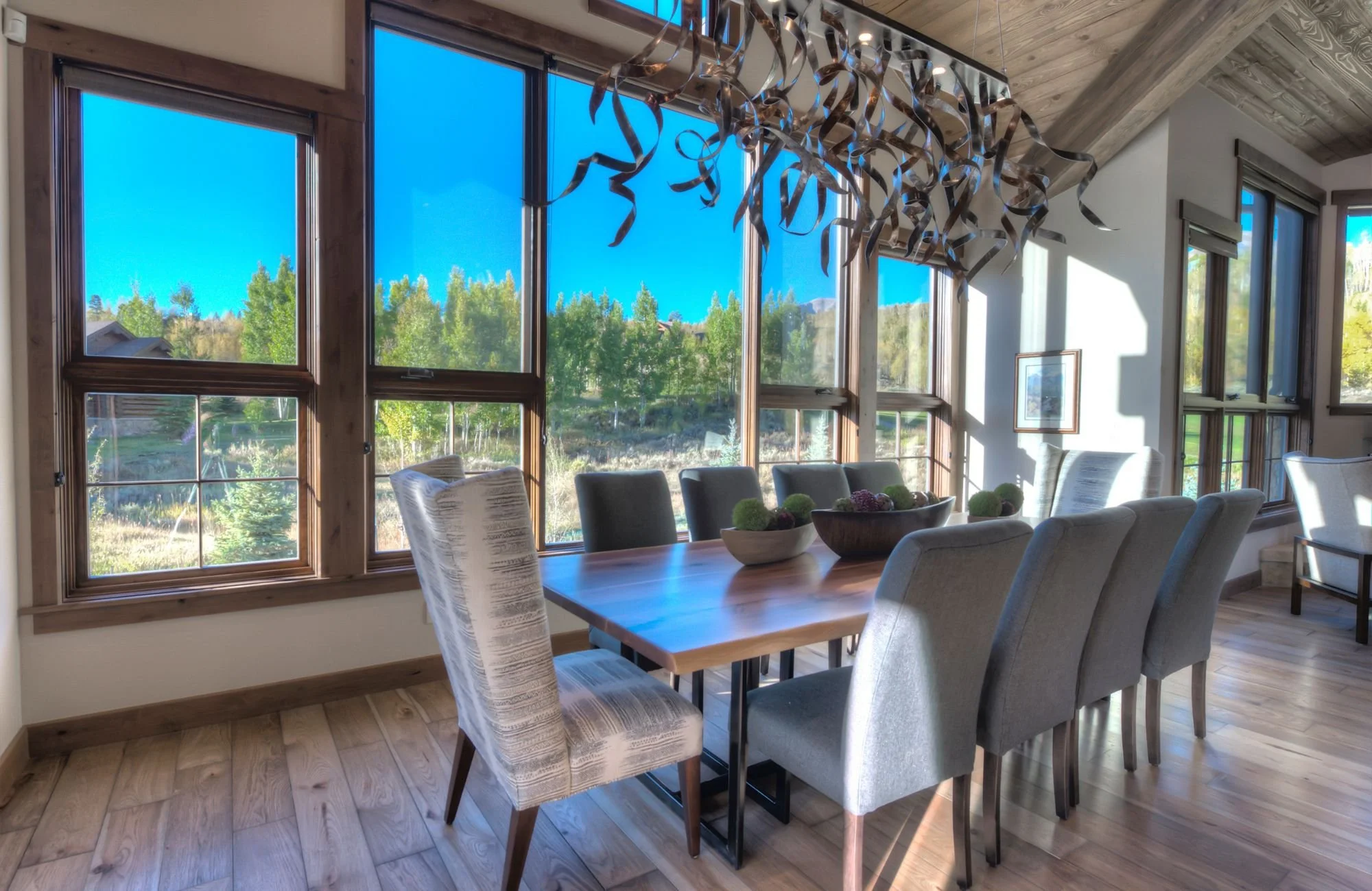 harmony-interiors-keystone-co-second-home-in-mountains-dining-table-with-large-windows-overlooking-mountains-unique-new-construction.jpg