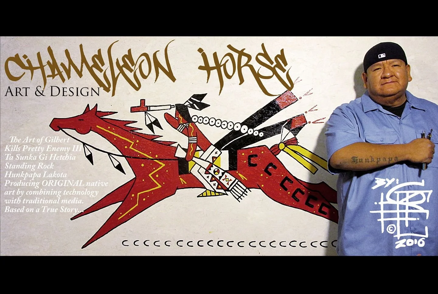 Portrait of a man with tattoos standing in front of a mural. The mural features a red dragon with a figure riding it, carrying a spear, and adorned with traditional indigenous art elements. Text on the mural includes "Chameyon Horse Art & Design" and