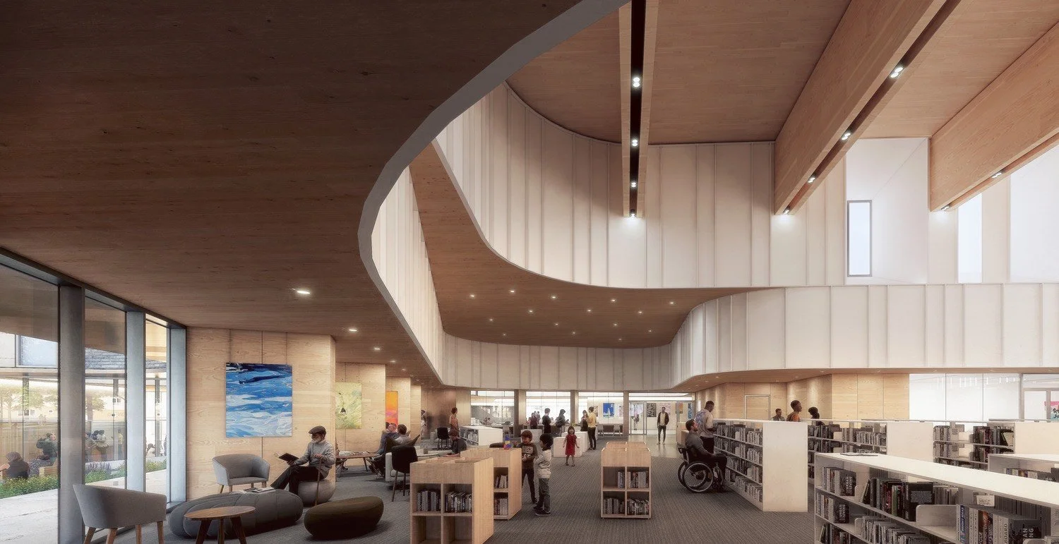 A spacious modern library with wooden ceiling and walls, large windows, and several people reading, walking, and sitting in chairs and at tables.