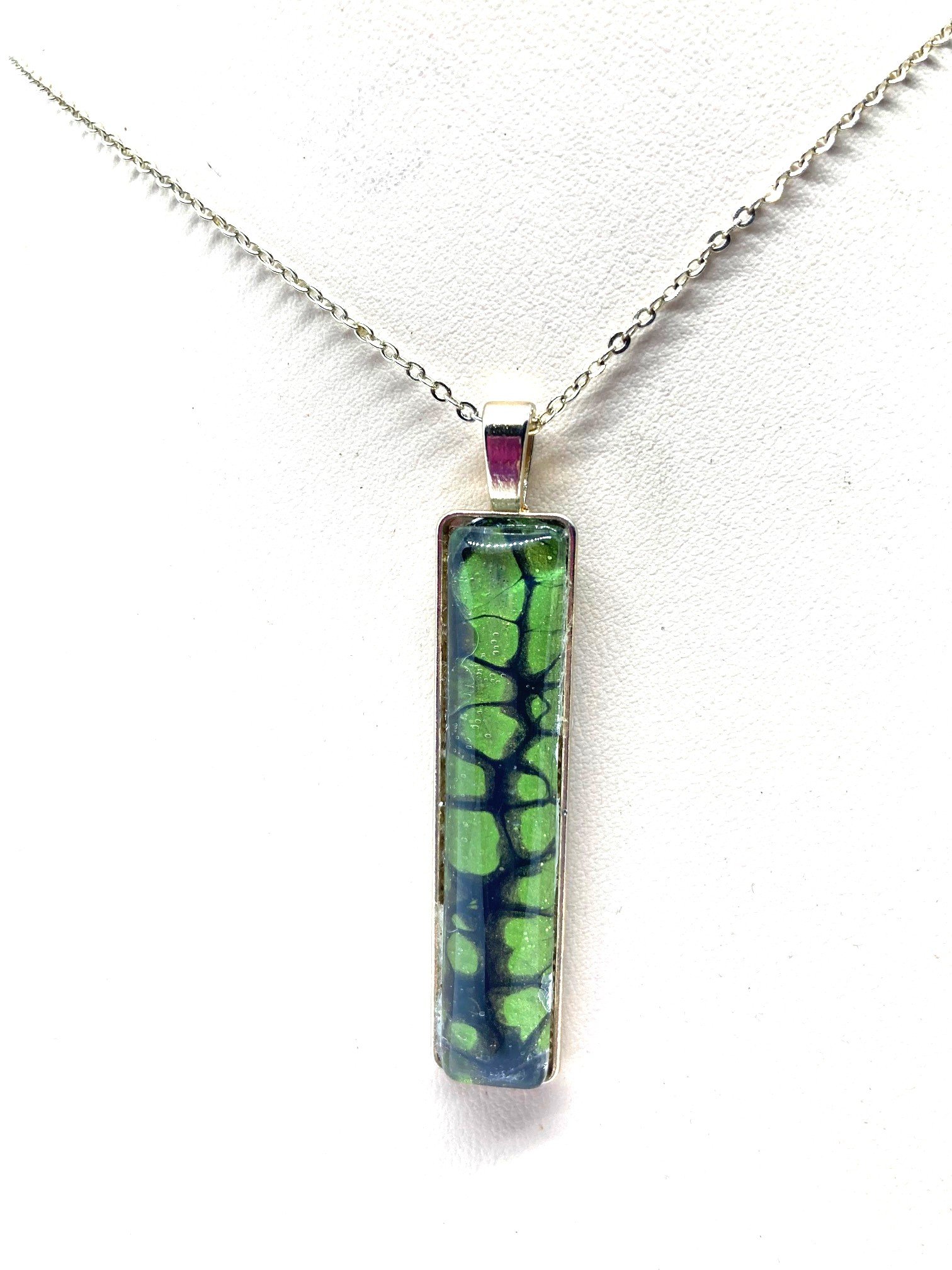 AcrylicPourNecklace_RectangleBezel_GreenandBlackChasmCloseUp.jpg