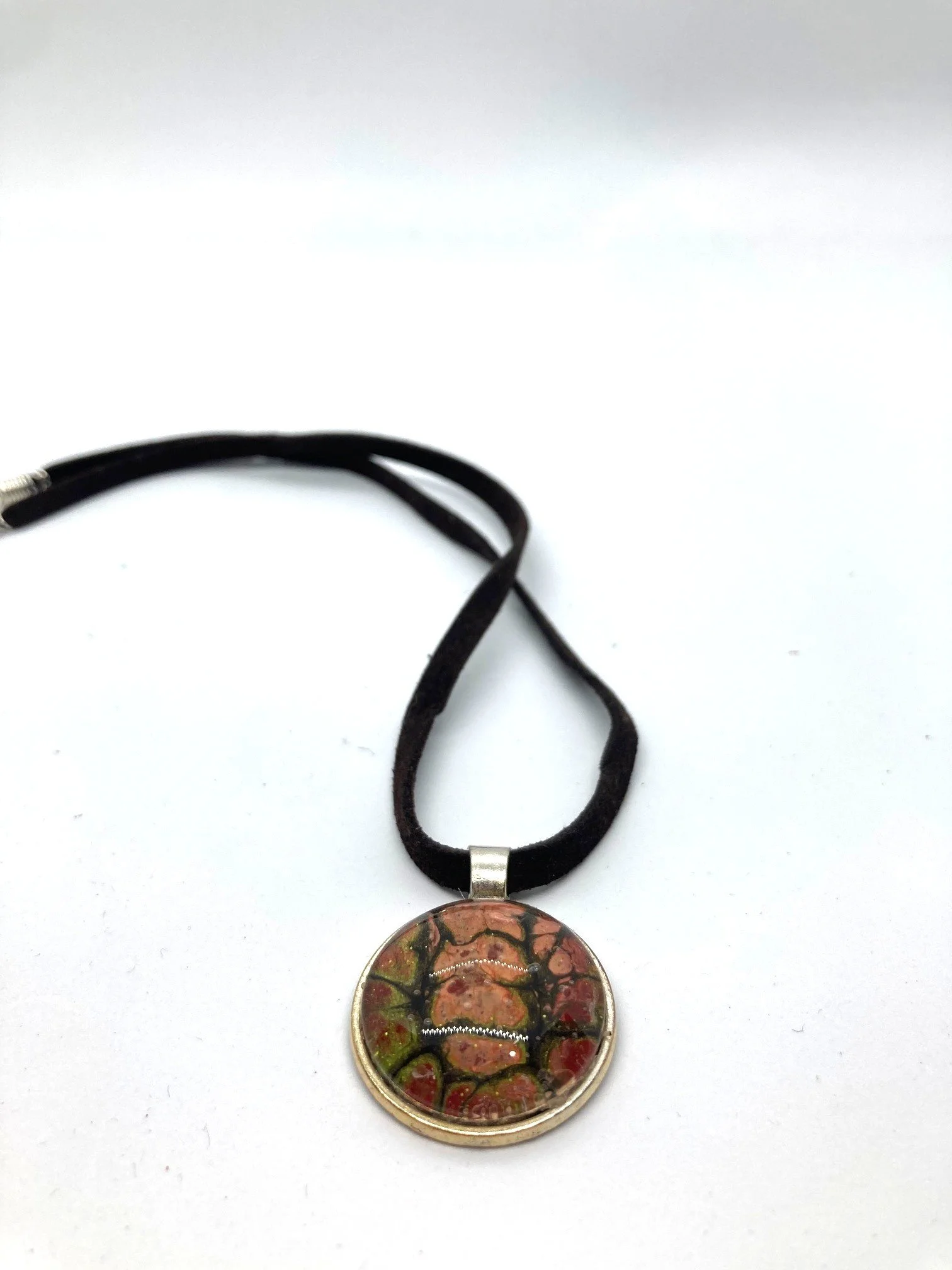 AcrylicPourNecklace_RoundBezel_Cord_PeachGrnRedChasm_LaidOut.jpg