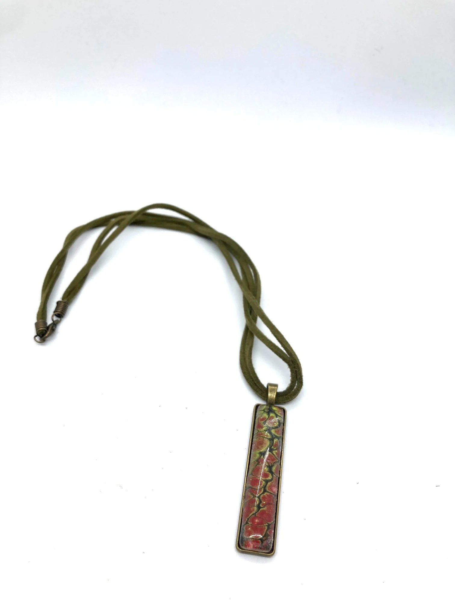 AcrylicPourNecklace_RectangleBezel_GreenandRedChasm_KhakiCord_LaidOut.jpg