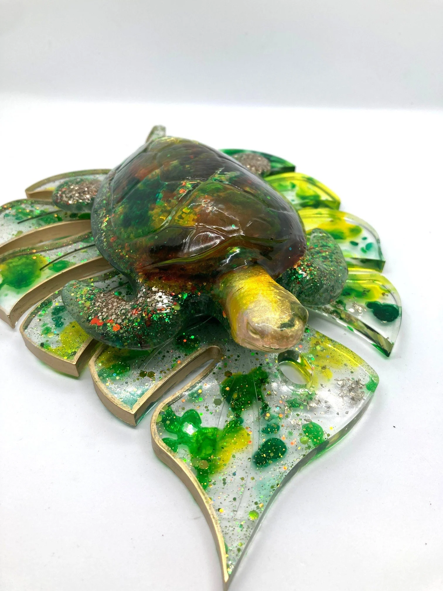 Ocean's Charm Resin Sea Turtle "Golden Rainbow" Figurine on larger leaf