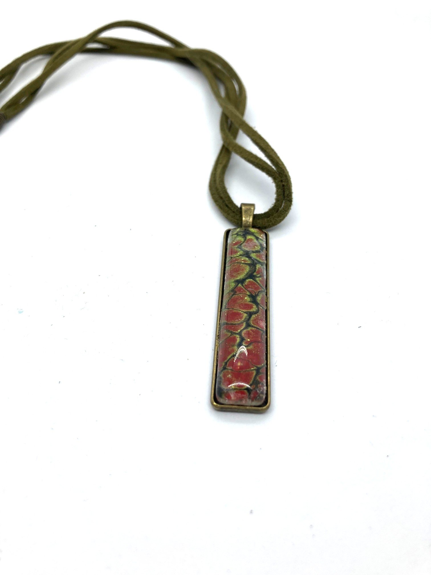 AcrylicPourNecklace_RectangleBezel_GreenandRedChasm_KhakiCord_LaidOutCloseUp.jpg