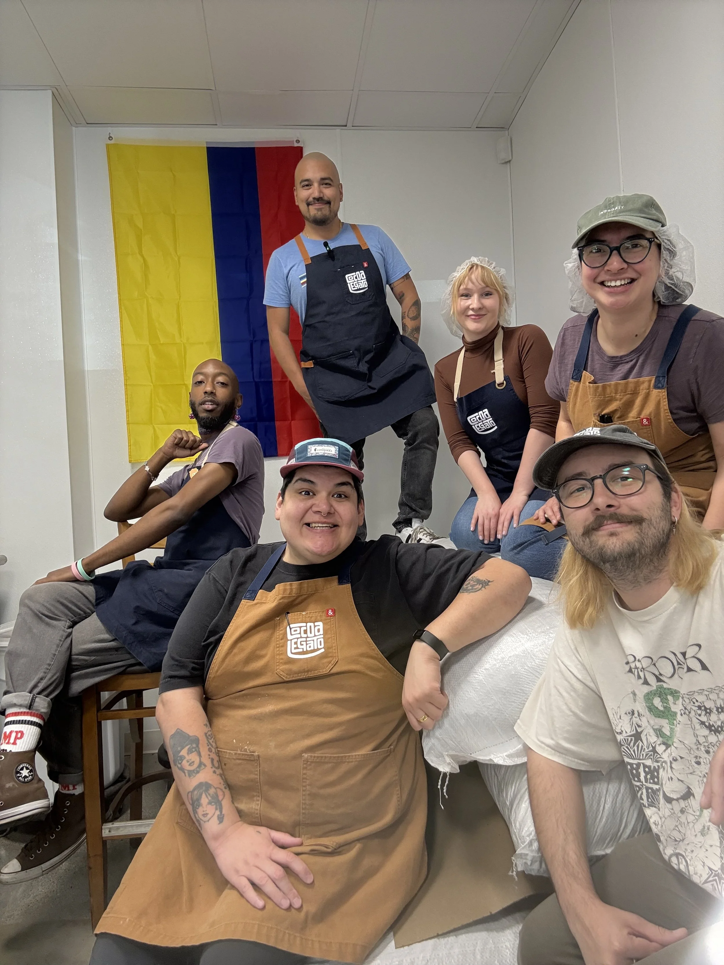 **Alt Text:**   A ripe, orange-brown cacao pod resting on a pile of dried cacao beans, displayed on a rustic wooden surface. The pod has a ridged texture, and the beans are dark brown with a slightly rough appearance.