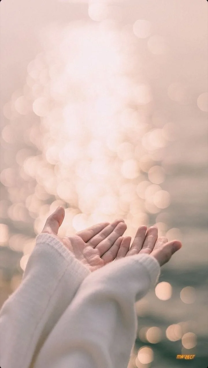 Calm image of hands reaching toward sunlight reflecting on ocean water, representing healing, emotional freedom, and trauma-informed therapy.