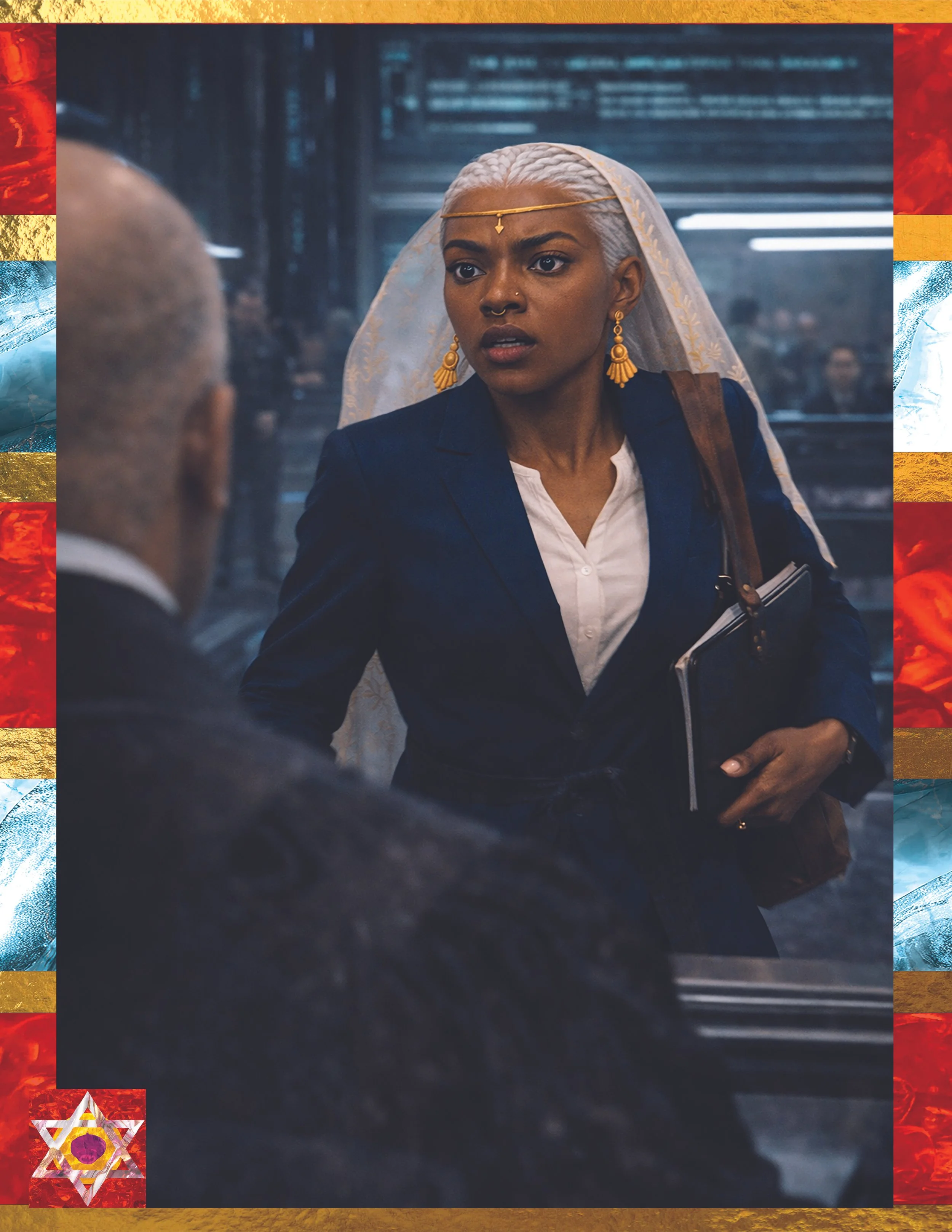 A woman with platinum blonde braided hair wearing gold jewelry, a nose ring, and a dark blazer, looking surprised or concerned, with a person in the foreground in an indoor setting.