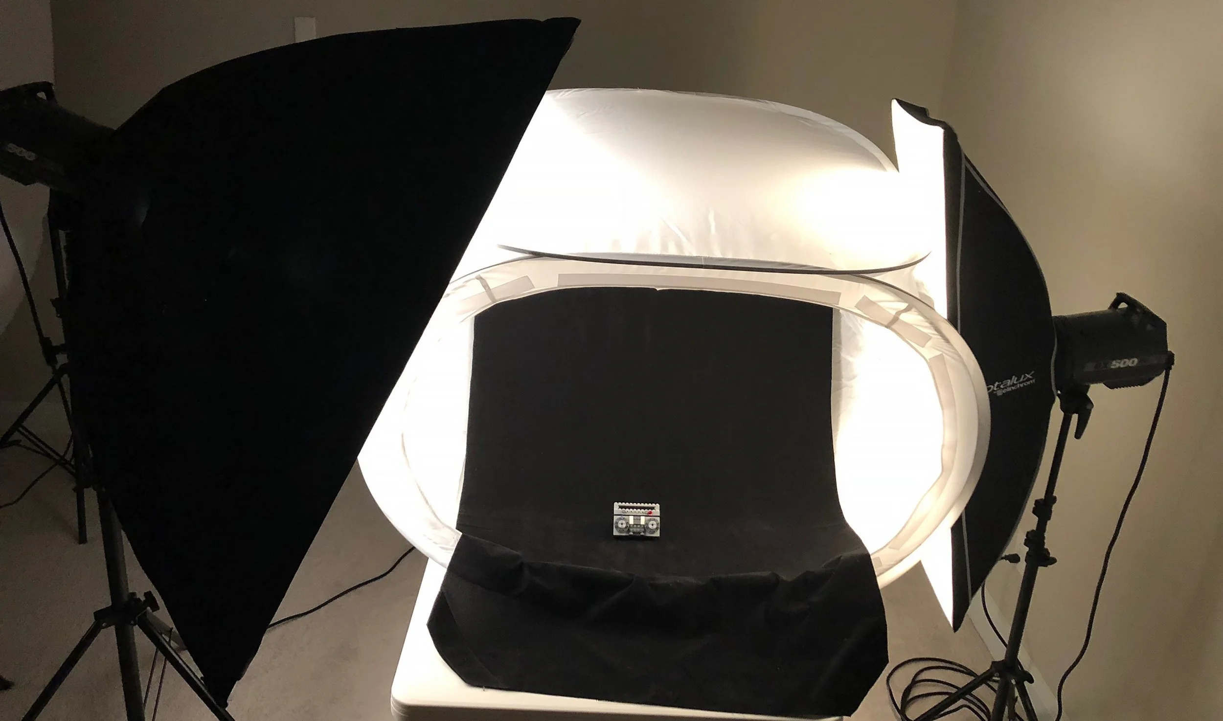 Set up the light tent on sturdy table, making sure that there is enough room on the sides and top for lights and stands.  The sweep is really important with this setup since the goal is to absorb as much light as possible.  I like to use a piece of b