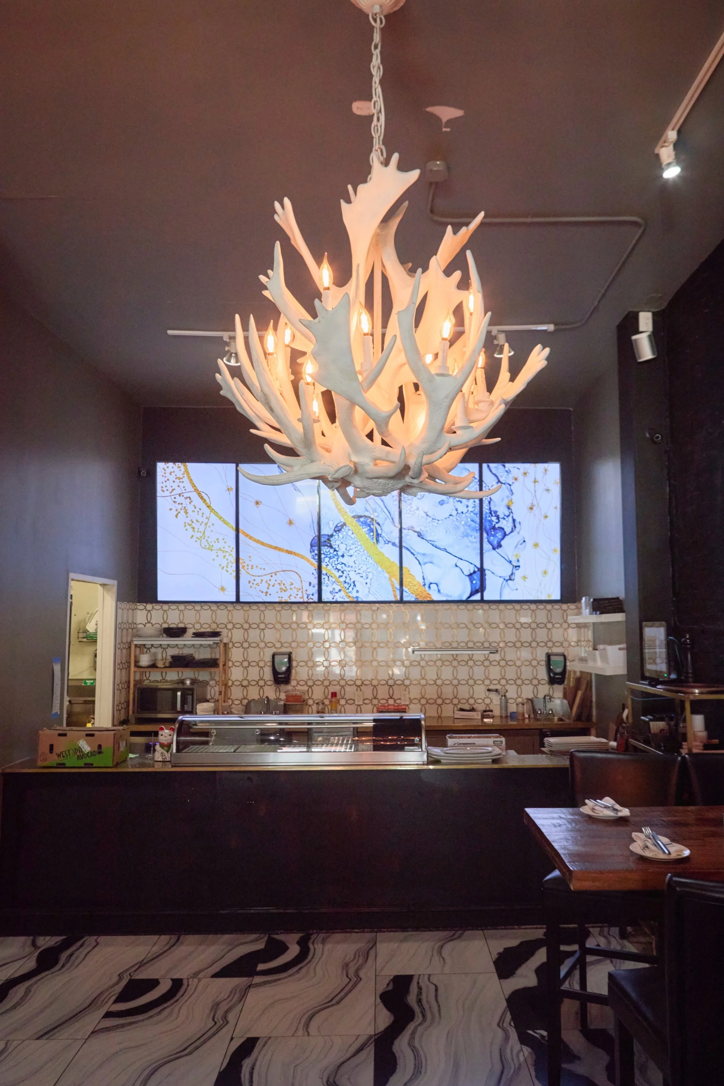 South Village Grille bar area with antler chandelier and artistic video wall, styled for private dining and events in German Village.