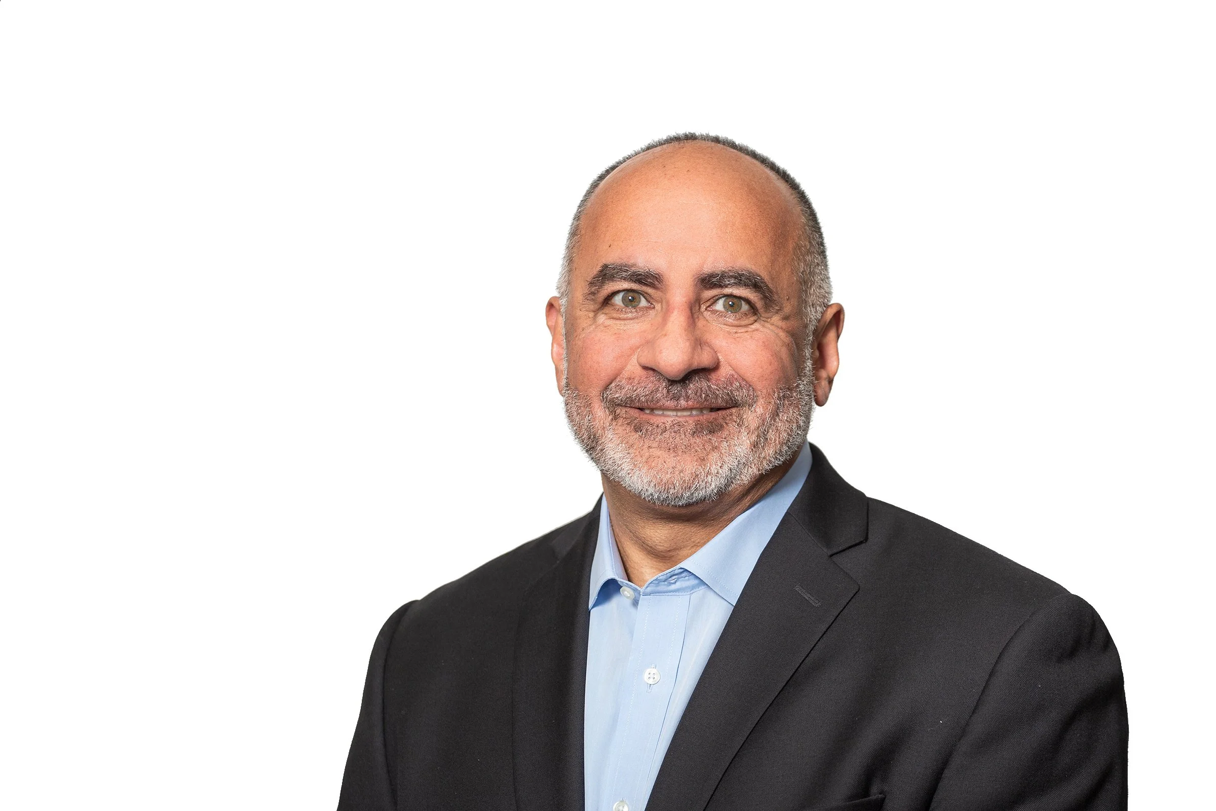 A smiling man in a dark suit and light blue shirt against a plain white background.