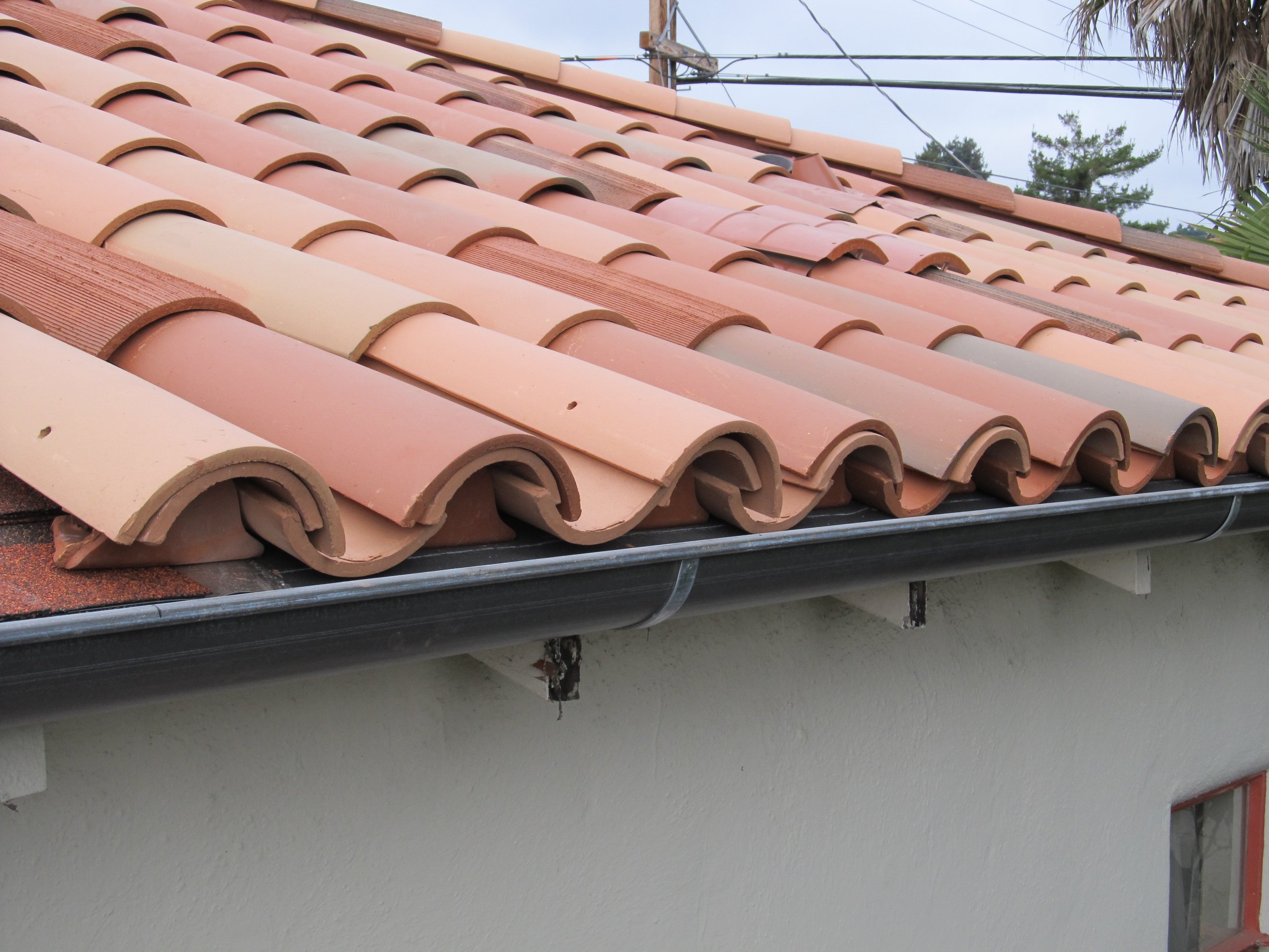 Close-up of a roof with terracotta-colored curved clay tiles.