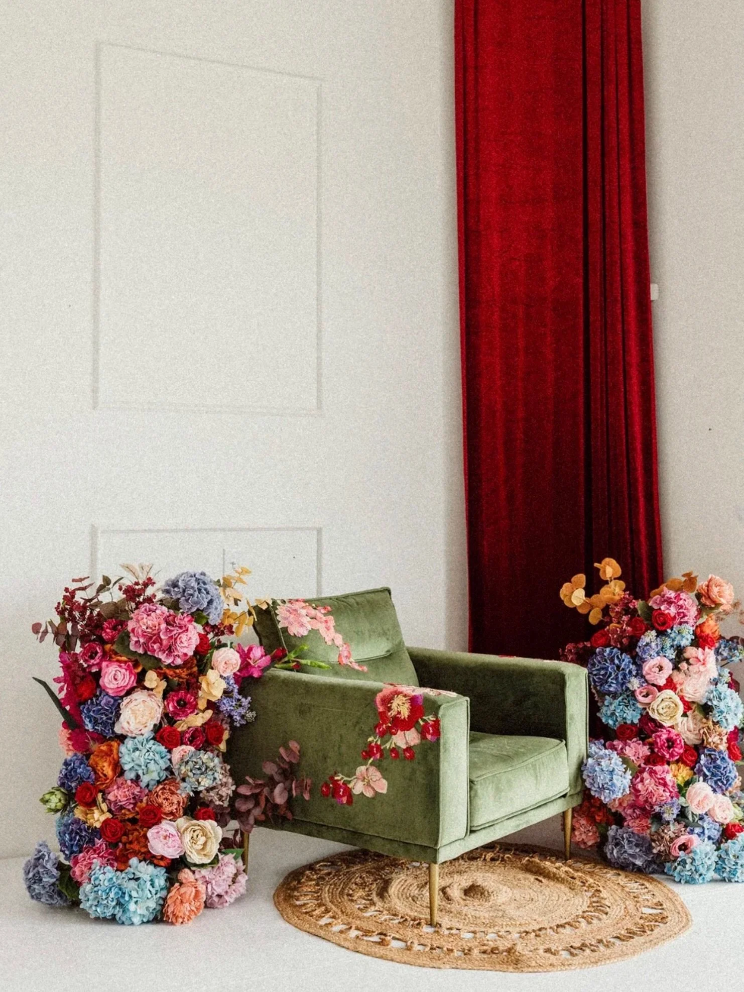 RICHLY ROOTED 🕯️

There is a certain weight to a space when the textures and tones are chosen with intention. 🕊️

Our newest setup pairs the deep, grounded hue of an olive velvet armchair with the bold drama of a red velvet backdrop and an explosio