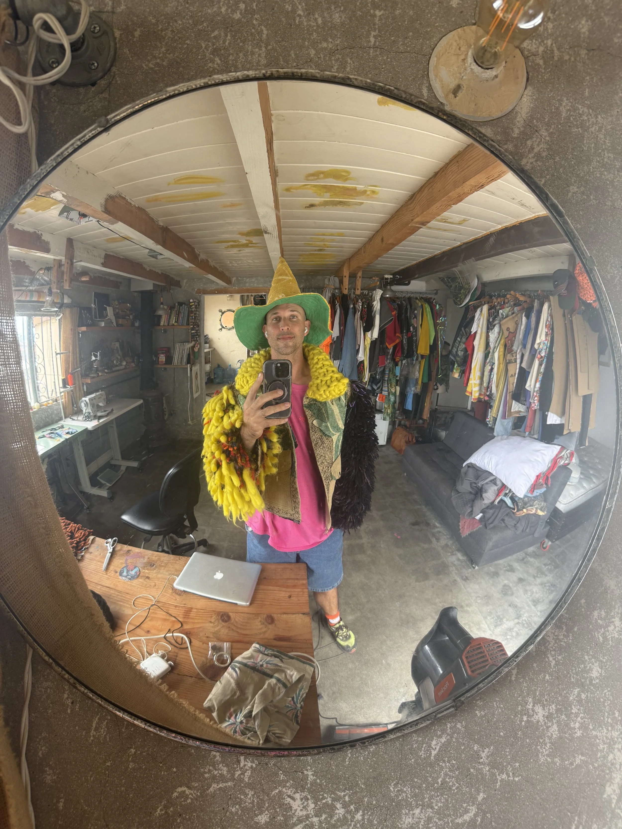 Addison Stonestreet wearing the black and yellow shaggy TIC jacket in a studio mirror portrait.