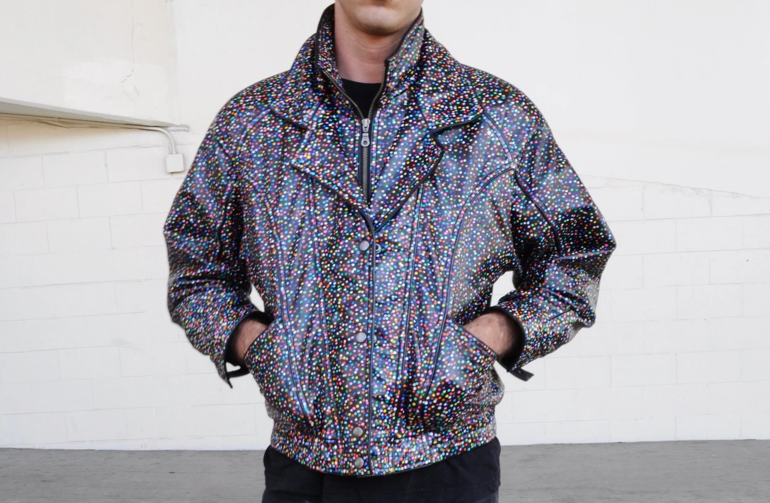 Front view of a black leather motorcycle jacket covered in thousands of tiny hand-painted dots in multiple colors.
