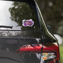 Purple flower sticker on the back window of a black car