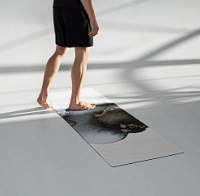 Person standing on a skateboard, inside a skatepark or indoor court.