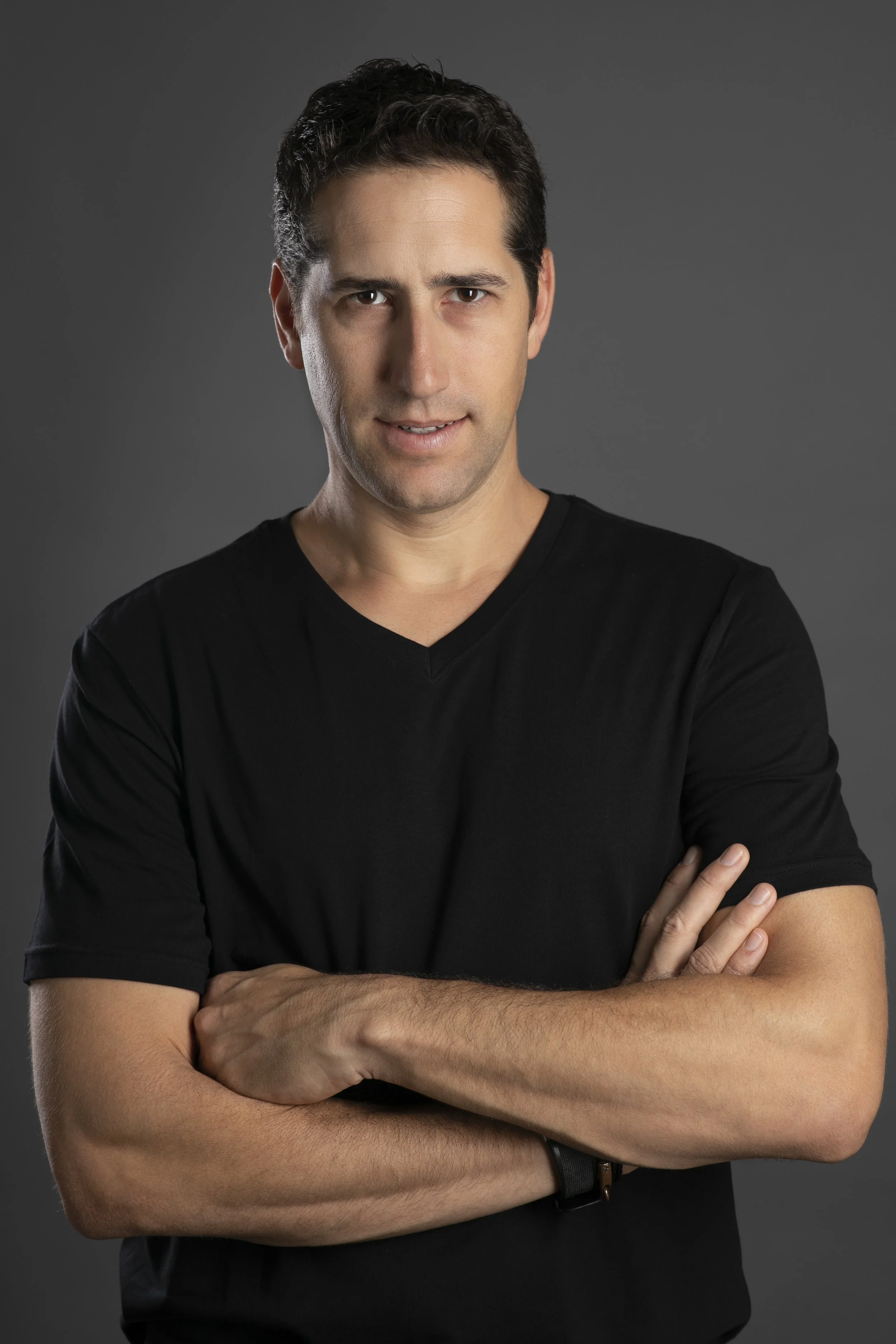 Image of man in black t-shirt with arms crossed