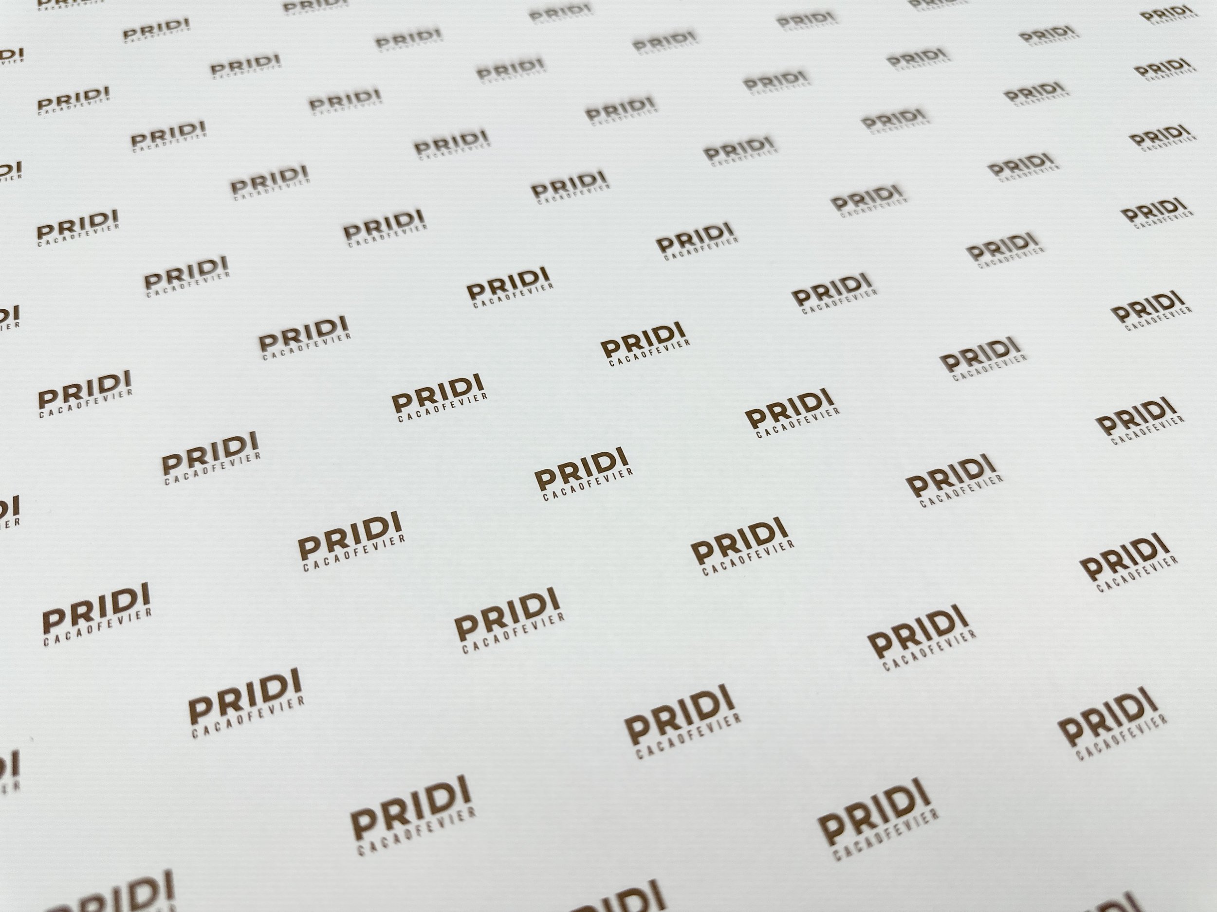 Repeated logo pattern of "PRIDI Cacaofevier" on a white background.